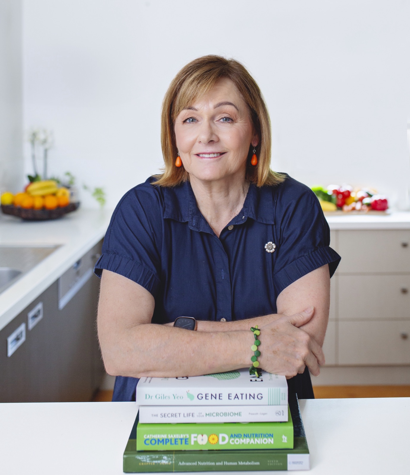 Dorelle Thompson, Accredited Practising Dietitian in Brisbane, leaning on a stack of nutrition reference books